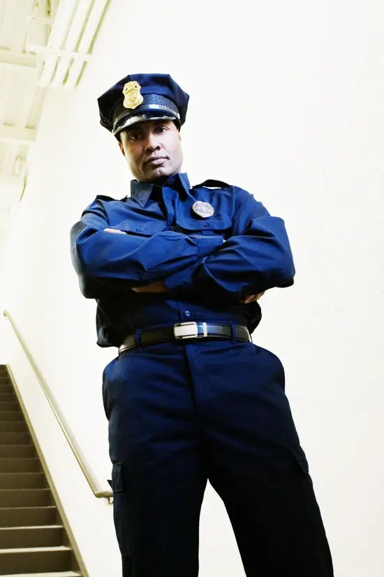 A man in blue uniform standing on stairs.