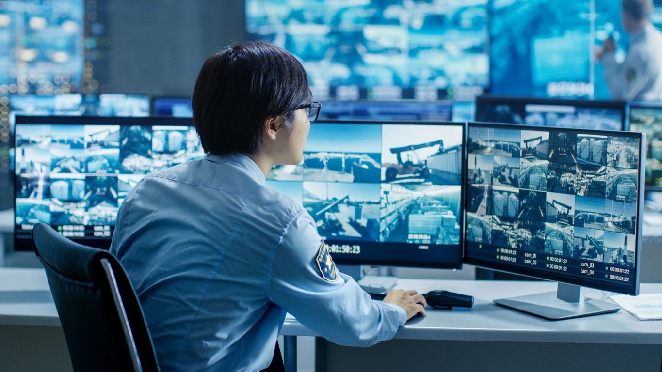 A man sitting at his computer in front of multiple monitors.